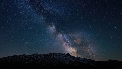 Naklejka premium The night mountains are illuminated by the Milky Way, a breathtaking celestial view.