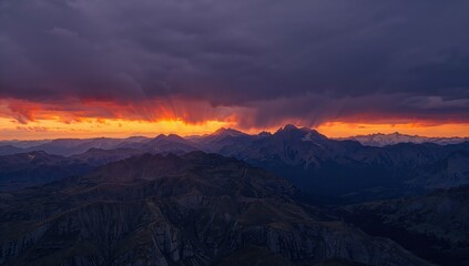 Aerial perspective of rugged mountains under a tempestuous sunset sky, erosion risk