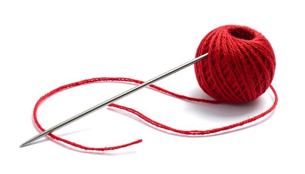 Metallic sewing needle with red thread and yarn ball on white background