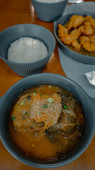 Bowl of braised pork stew wrapped in kimchi called kimchi jjim, rice, and fried chicken or chikin presented on a dining table, authentic traditional Korean dishes