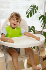 Funny baby girl eating red berries, red currants. Healthy snack for children, fruits as a source of vitamins