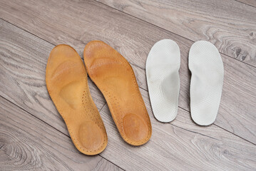 Family orthopedic insoles for adults and a child lying on the home floor and in shoes for valgus prevention and foot health