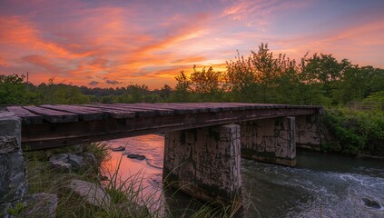 Fototapeta premium Old bridge spanning a water stream during summer evenings, erosion risk