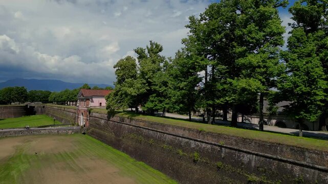 Aerial drone footage rising beside the fortified walls of Lucca in Tuscany, Italy