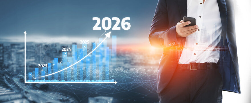 A businessman studies a smartphone while standing in front of a futuristic urban backdrop, highlighting a growth trend graph that suggests positive future projections for 2026. Tessel