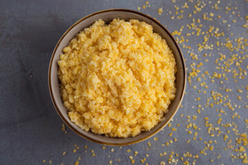 milk porridge with crushed corn grains on a gray background