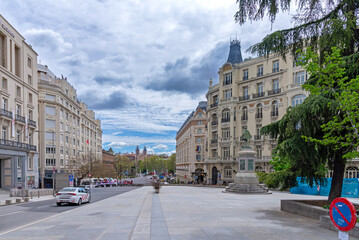 A typical street in central Madrid, lined with elegant historic buildings, balconies, and warm facades, capturing the city’s lively charm and timeless architecture