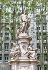 Close-up of Madrid’s Fuente de Cibeles, showing the white marble Cybele on a lion-drawn chariot atop a tiered stone fountain, all surrounded by lush green trees