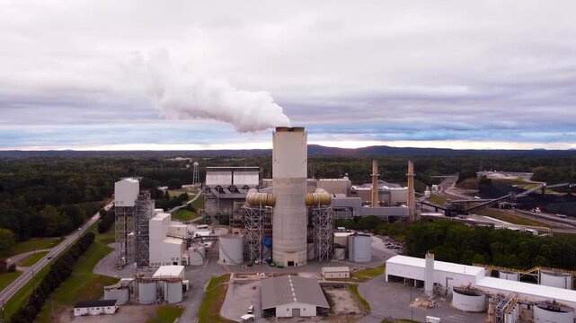 Coal power plant in Catawba on Lake Norman emits steam into a colorful sunset sky, aerial cinematic video.