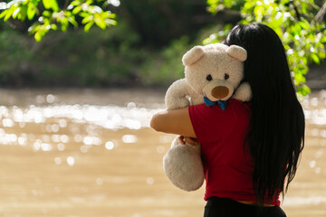 Sad woman with a stuffed toy to comfort herself.