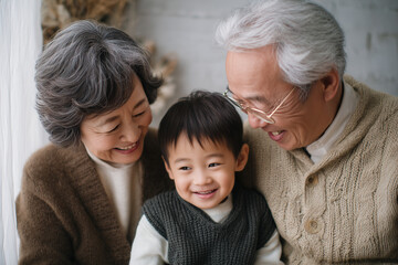 祖父母と孫が笑顔で寄り添う暖かいポートレート（家族の絆、世代間の愛） / Warm portrait of grandparents and grandchild cuddling and smiling (Family bond, intergenerational love)