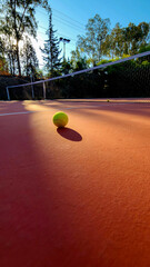 A detailed view of an empty tennis court and tennis ball.