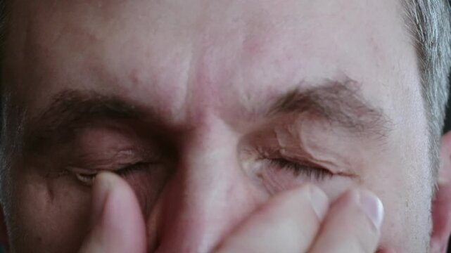 Close up of a man's eyes that are itchy and burning after a hard working day, problems with the eyes because of working behind the monitor 
