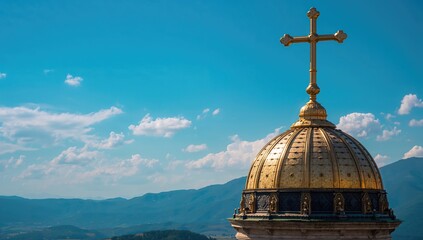 Christian Orthodox cross atop a dome with mountains and blue sky, cultural significance