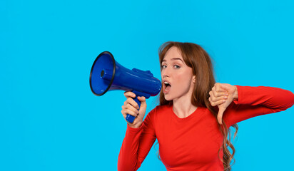 Young woman protests with a megaphone and thumbs down in blue