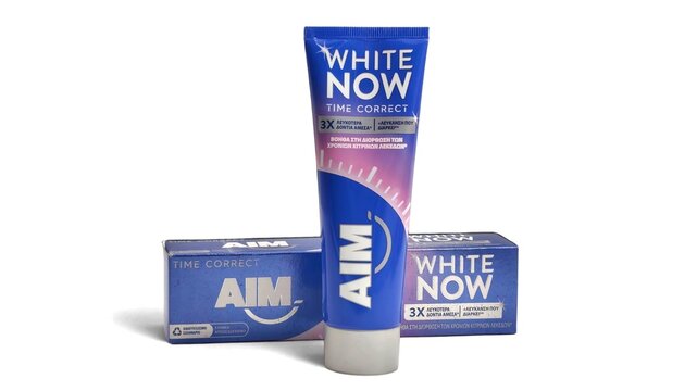 Photo of a 75ml AIM White Now Time Correct toothpaste tube, isolated on white background. AIM is a brand of toothpaste from Church and Dwight (Unilever until 2003).