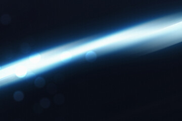 Blue glowing diagonal light with bokeh and dust grain overlay on dark background. Atmospheric abstract texture ideal for cinematic visuals, web headers, banners, digital design, music covers, overlays