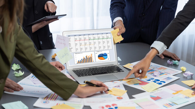 Analyst team use sticky note for creative and analytic brainstorm for business idea with BI data dashboard on laptop screen. Analysis financial data visualization tech for marketing strategy. Prodigy