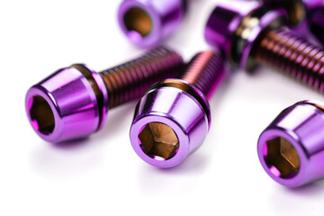 A scattering of titanium bolts in the macro are arranged on a snow-white background