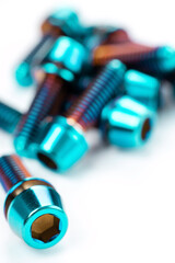 Sturdy titanium hex bolts are positioned on a snow-white background, close-up
