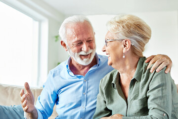 Portrait of a happy senior couple embracing hugging and having fun at home