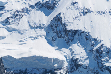 High mountains with snow-covered avalanche-prone eaves