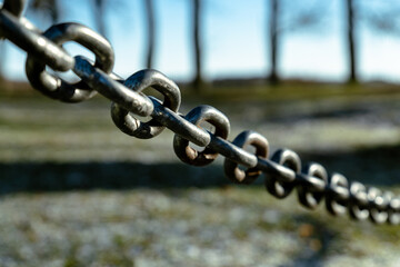 Diagonal Metal Chain in Winter Sunlight with Soft Blurred Background