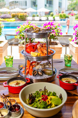 Indulge in luxurious seafood platter by resort poolside; fresh oysters, lobster, shrimp, and mussels; perfect summer dining and vacation experience.
