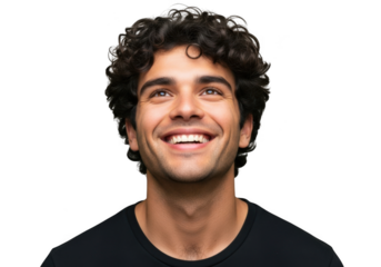 A young man with curly dark hair and a bright genuine smile looking upwards with joy and optimism isolated on transparent background