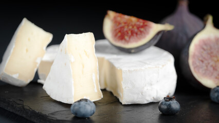 Fresh cheese and figs on a black table