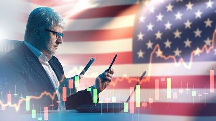 Financial trader monitors U.S. stock market trends using smartphone and laptop. Investment analysis and economic forecasting in American finance sector.