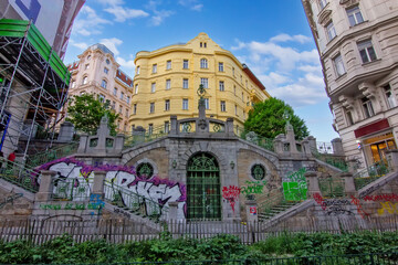 a historic stone staircase and archway covered in colorful graffiti