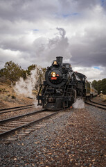 Historic steam locomotive approaching on railway tracks