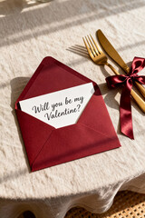 Valentine's Day invitation on a table with elegant decor and gold utensils