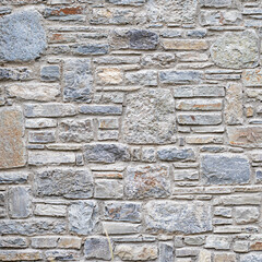 Rough stone wall texture with varied gray, beige, and blue stones for a rustic backdrop