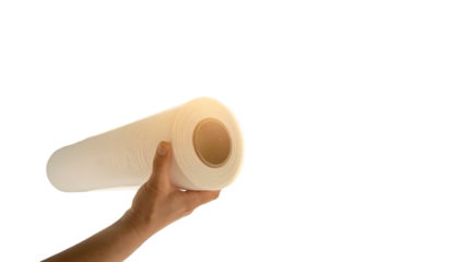 Human hand holding a large roll of white paper against a black background