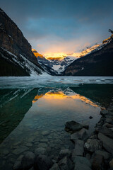 Golden sunrise reflection on frozen Lake Louise