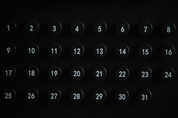 Set of black numbered buttons from 1 to 31 forming strict, minimalist calendar layout against a dark background.
