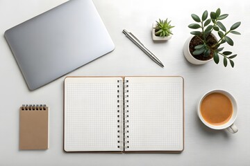 Overhead shot of a workspace with laptop, notebook, pen, plants, and coffee