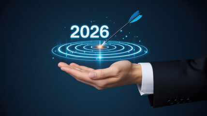Hand holding a target with the year 2026 representing future goals and business strategy on a dark blue background