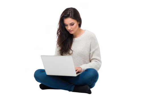 A young woman with long dark hair wearing a white sweater and blue jeans sits cross legged working on a laptop isolated on transparent background