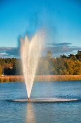 Barlinek (niem. Berlinchen) – Wysoka fontanna tryska z spokojnego jeziora, rozpryskując mgiełkę w jasnoniebieskie niebo. © Pol Badger