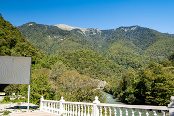 The panorama of majestic mountain peaks, adorned with lush greenery, appears in all its glory on a warm autumn day.