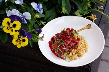 Lamb Rack With Pomegranate Glaze And Creamy Risotto In A Colorful Garden Setting