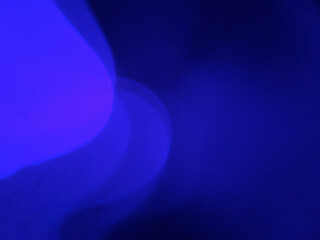 Enchanting blue-purple bokeh with soft layered light diffusion creating cool-tone atmospheric glow and ethereal luminous effect against dark background. Authentic film photography artifact showcasing 