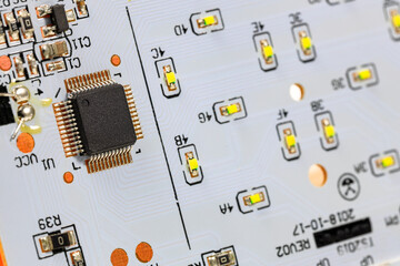 Controller module on LED light module board, electronic circuit panel with surface mount diodes on gray PCB. 