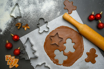 Festive baking scene with rolled gingerbread dough, assorted Christmas cutters and flour details. Great for winter holiday visuals, cozy family kitchen themes, recipe content, Christmas promotionals.