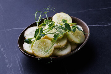 Fresh Cucumber Salad With Microgreens In A Dark Brown Bowl