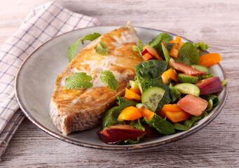 Fried white fish steak with salad