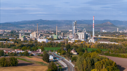 Aerial view of large cement factory complex with industrial smokestacks and quarry, Lafarge cement plant, Czech Republic